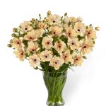 a vase of flowers in cream pink colour
